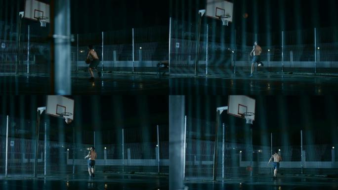 运动年轻的男子篮球运动员运球并在围栏的街球场上扔球。进了一个两分球。居民区雨后的夜间录像。