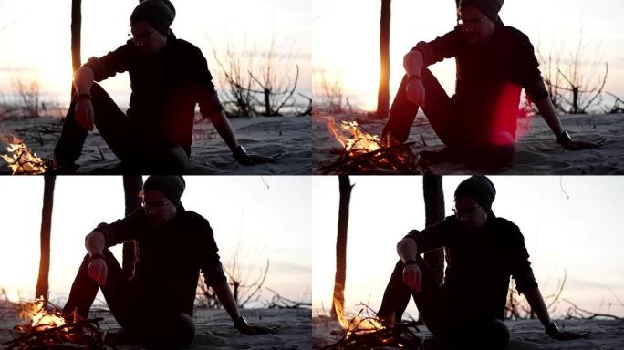 男子在海滩营地享受篝火