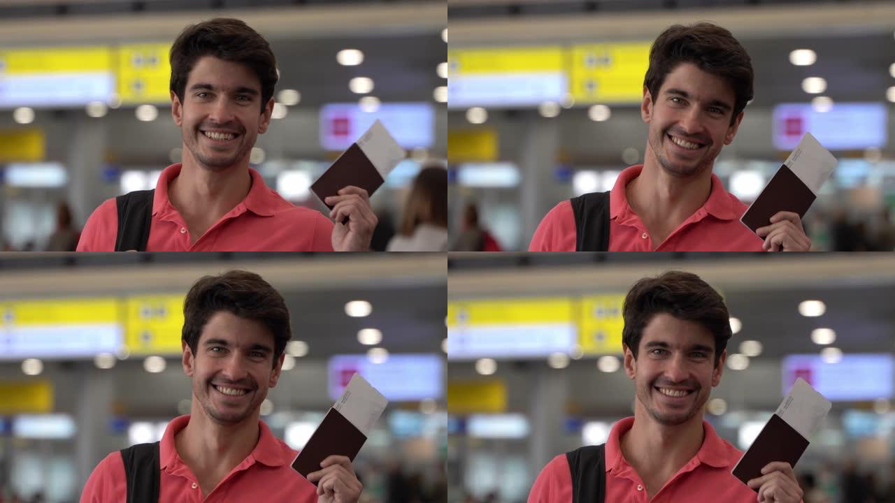 高加索英俊男子拿着护照和登机牌在机场准备旅行，面对镜头微笑