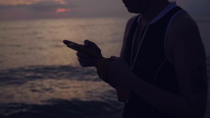 在芭堤雅海滩用智能手机发短信的快乐女人。