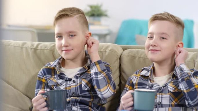 10岁的高加索双胞胎兄弟齐声揉着耳朵