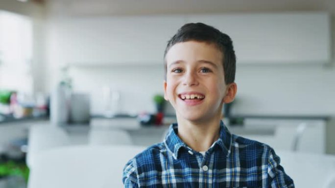 一个棕色眼睛的小男孩在厨房背景下看着相机的肖像。