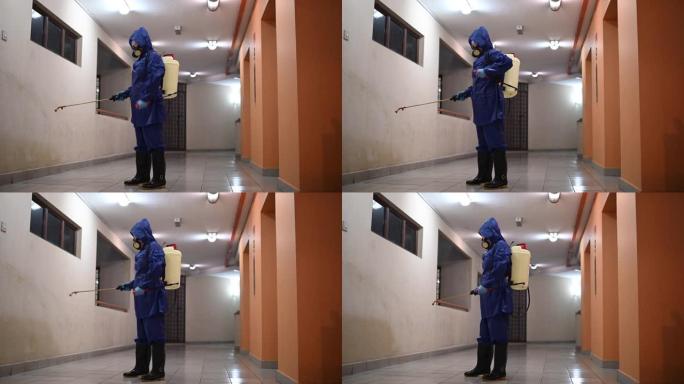 一名妇女穿着防护服喷洒和消毒走廊灭虫病毒