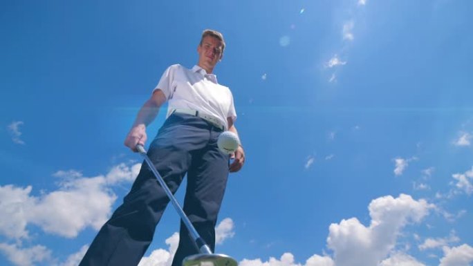 一名男子用金属球杆玩弄高尔夫球。