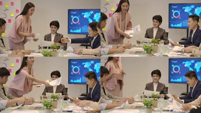 提交工作计划业务报告的迷人亚洲女性在公司会议上向她的团队提交论文，在办公室简报会上做文书工作的多元化