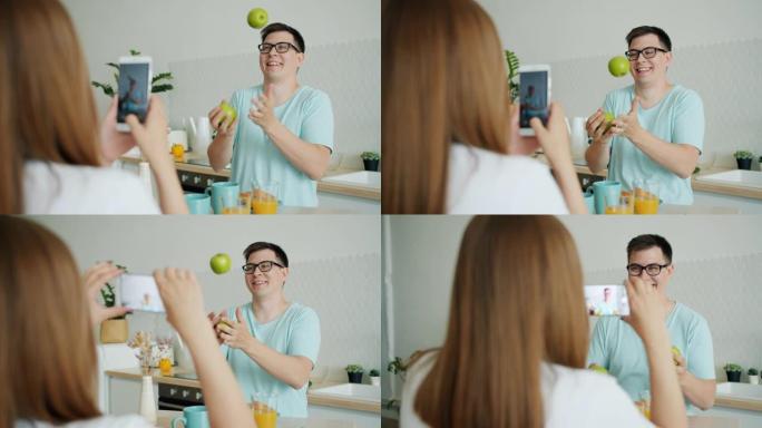 男人在用智能手机拍照时玩苹果的慢动作