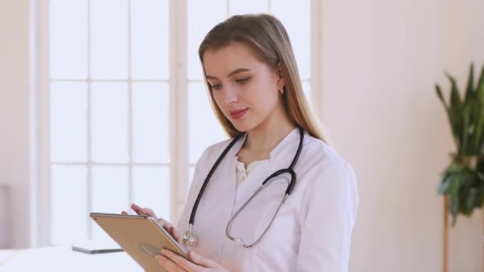 女性专业医生穿着白色制服拿着使用数字平板电脑