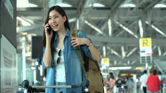 在航站楼机场的登机口，年轻的休闲妇女在智能手机上聊天。年轻妇女独自乘飞机旅行。