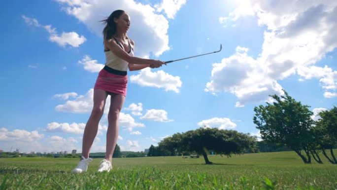 一个女孩在草地上打高尔夫球。