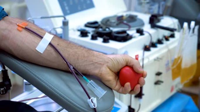 男性的手在献血时挤压球