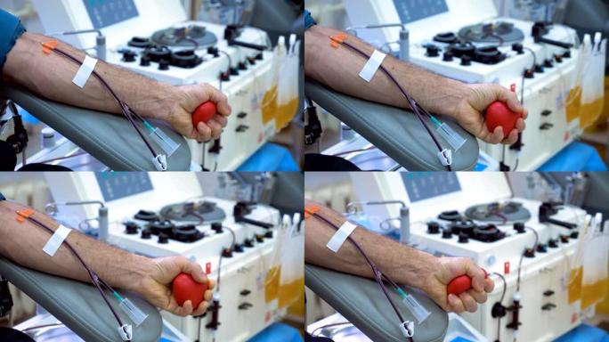 男性的手在献血时挤压球