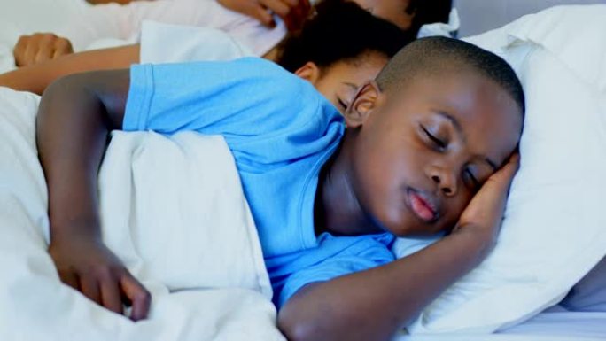 舒适家庭4k卧室里一起睡在床上的年轻黑人家庭的前视图