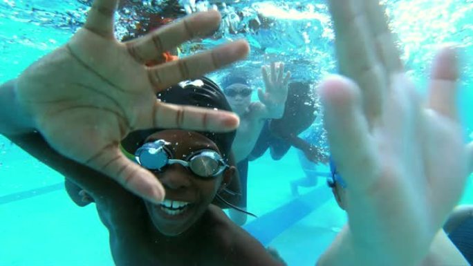 多种族儿童在水下挥舞着相机