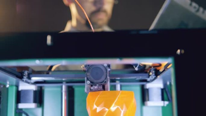 一位拥有平板电脑的工程师正在观察3d打印机制作花瓶
