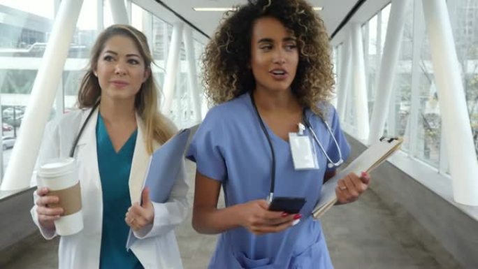 忙碌的女性医疗保健专业人员走在医院的天桥上