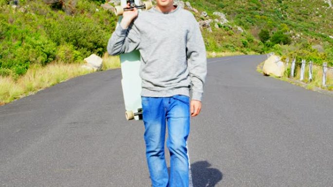 酷年轻高加索男子的侧视图，滑板行走在4k乡村路