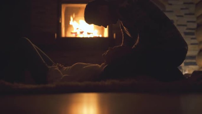 幸福的夫妻在壁炉旁休息