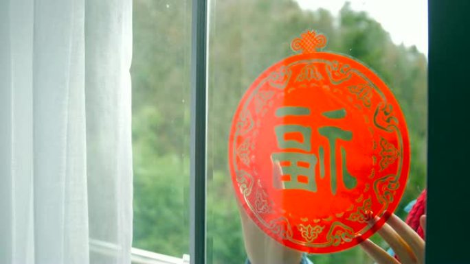 女人把中国传统剪纸放在窗户上