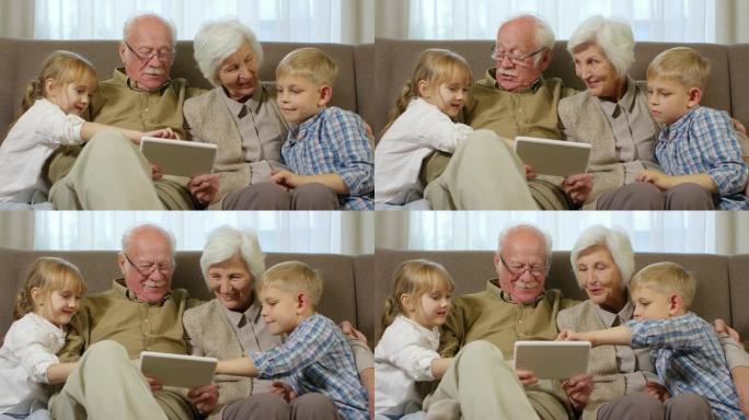 祖父母与孙子孙女在平板电脑上玩游戏