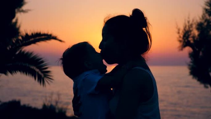 日落风景和一个女人和她的孩子鬼混。母亲和孩子。