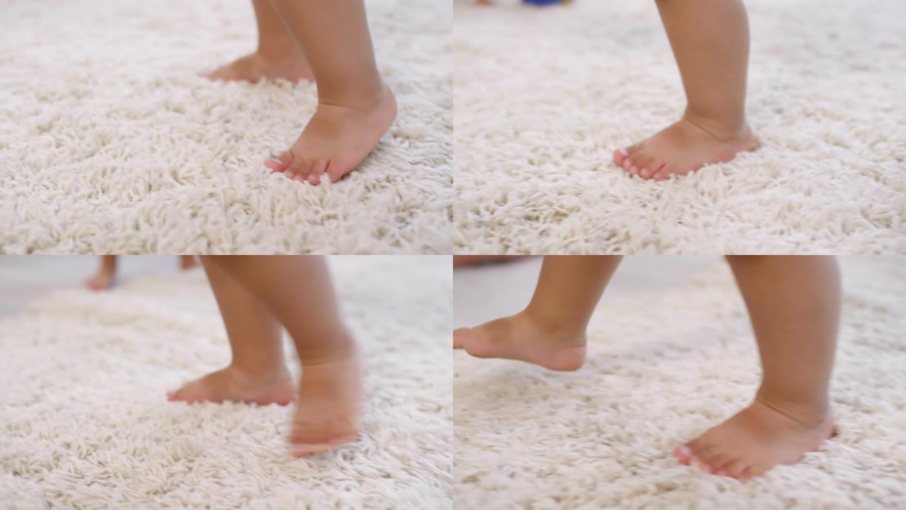 无法识别的赤脚幼儿的腿在地毯上学习走路