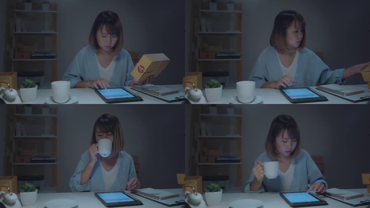 亚洲年轻企业家商业女性中小企业在线检查库存产品，保存到平板电脑，在家深夜工作喝咖啡。家庭办公室概念的