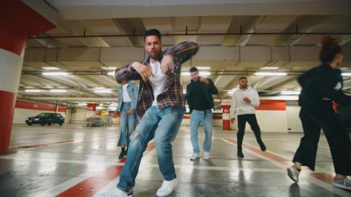不同种族的年轻城市舞者的慢动作正在地下停车场进行训练