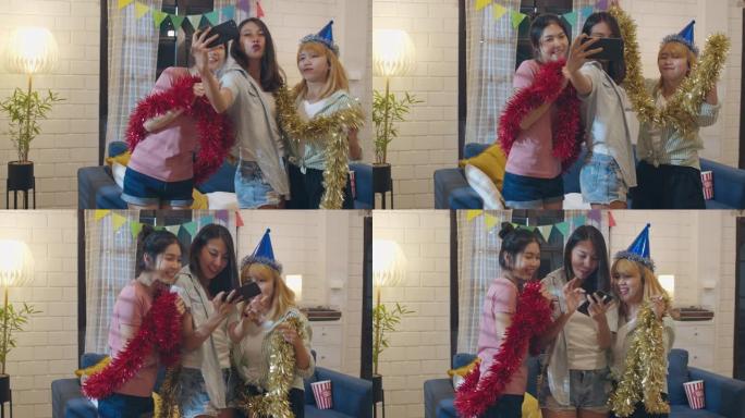一群亚洲女性在家里聚会，女性使用手机在社交媒体上制作vlog自拍照，晚上在客厅一起跳舞。年轻朋友庆祝