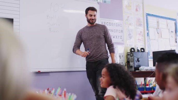 站在白板上的男老师在学校教室里问小学生问题