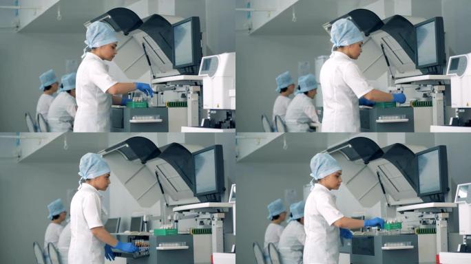 实验室工作人员将试管重新安置到生化分析仪中