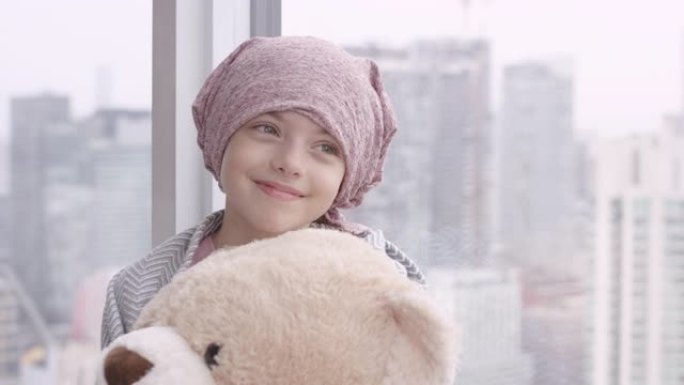 一个拿着毛绒玩具的癌症女孩的肖像