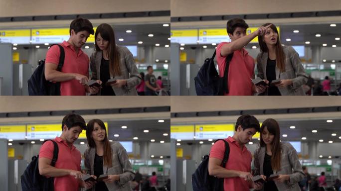 幸福的夫妇一边看着他们的登机牌，一边准备在机场旅行