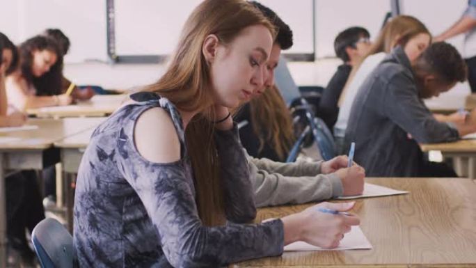 教室课桌上的一群大学生参加考试