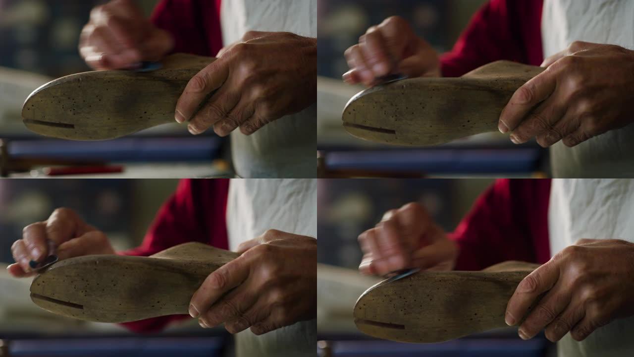 一个鞋匠在意大利鞋厂砍刀并准备工具的特写。