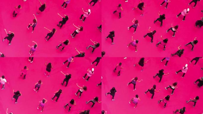 在粉红色地板上的运动课上跳舞的俯视图人群