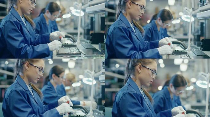 穿着蓝色工作服和防护眼镜的电子工厂女工正在用螺丝刀组装笔记本电脑的主板。拥有多名员工的高科技工厂设施