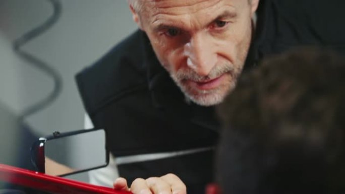 男教练在与赛车手交谈时握手