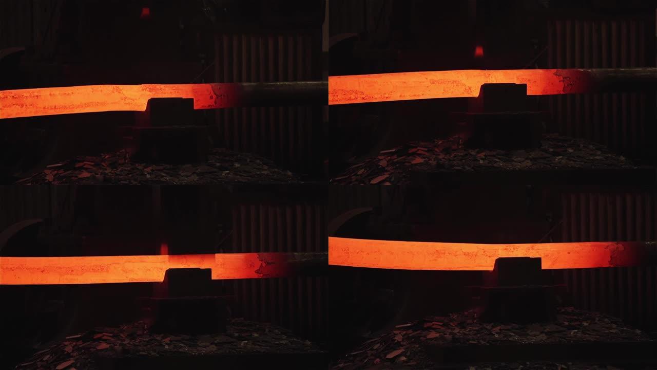 机器在铸造厂锤击一根发光的钢筋。