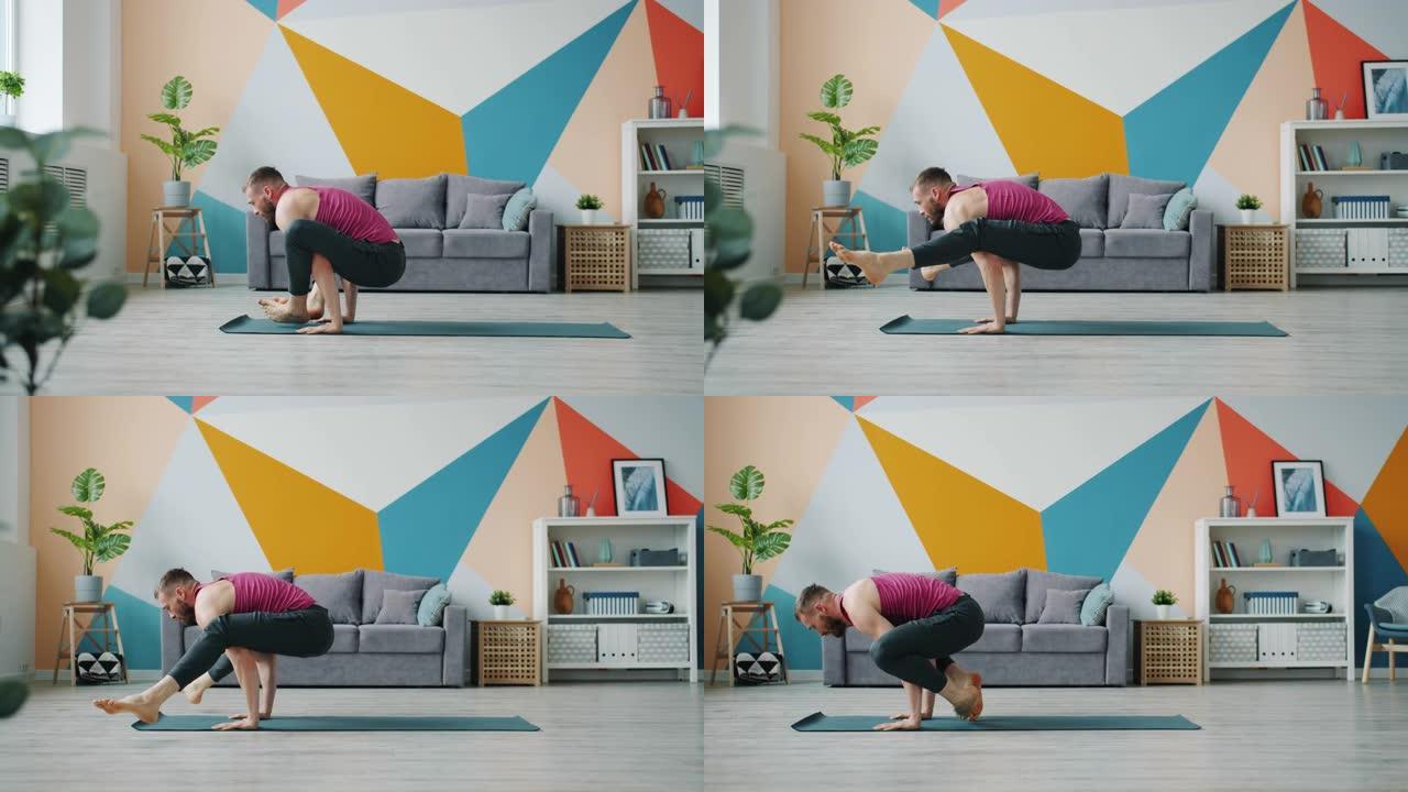 男瑜伽学生在家锻炼，在橡胶垫上做手臂平衡体式
