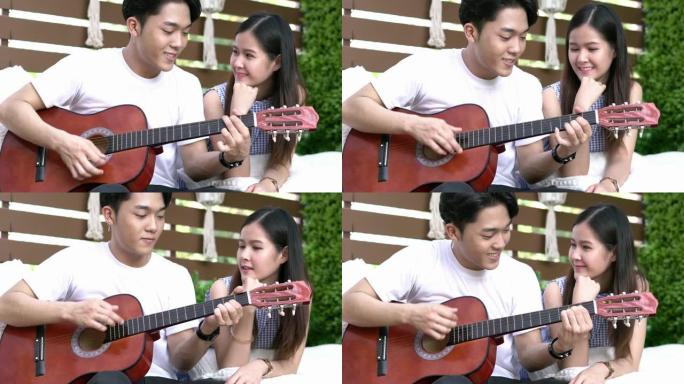 年轻夫妇在阳台后院弹吉他，快乐地唱歌。