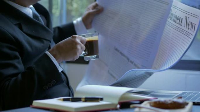 高级商人喝咖啡高级商人在咖啡馆里喝咖啡看报纸