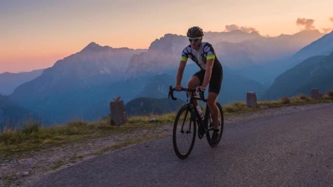 日落时在风景优美的路线上骑自行车，背景是山脉