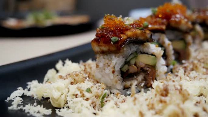 日本鹅肝卷，黑盘上烤鹅肝的米卷。日本美食风格