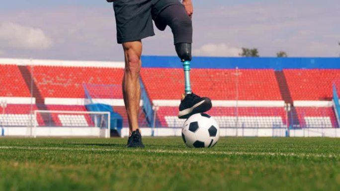 具有仿生腿的残奥会运动员正在踢足球，足球