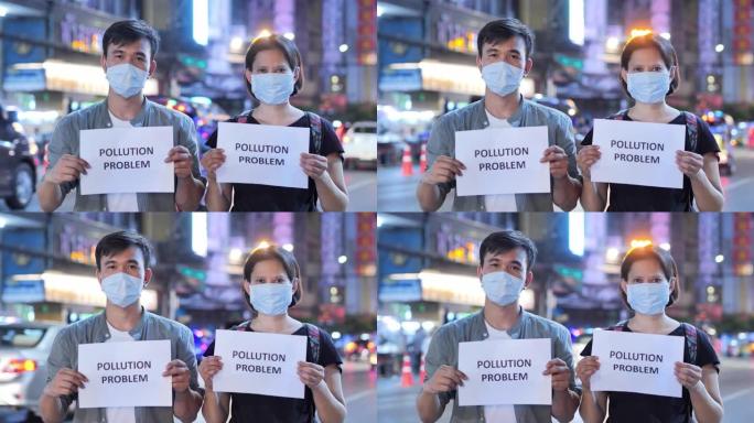 戴着防护面具并拿着纸卡写有 “污染问题” 字样的人。护脸以防止呼吸有毒空气。环境污染，生态灾难，人，