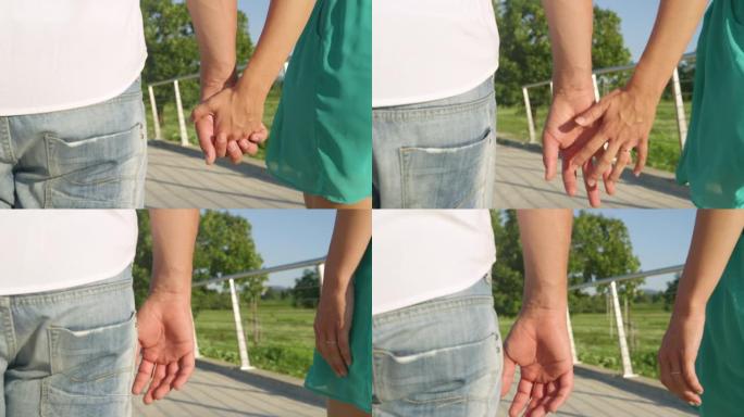 特写: 浪漫散步中无法辨认的情侣放开彼此的手。