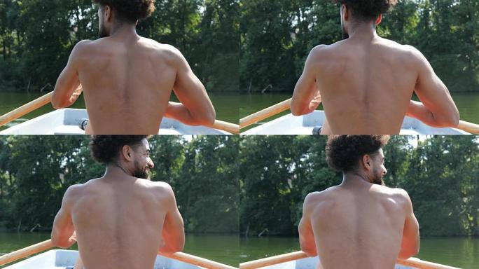 光着膀子的年轻人在森林的湖里划船