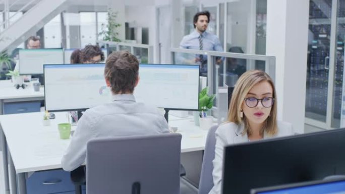 在繁忙的办公室中，各行各业的专业人员在台式计算机上工作，交谈，做客户支持，与客户沟通，监控统计数据，