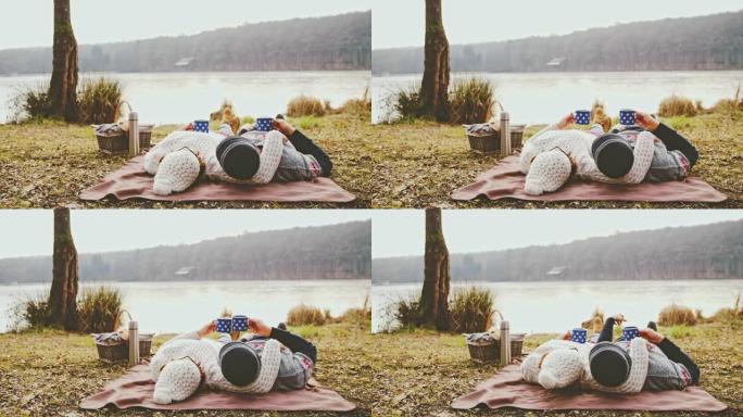 Serene女士，深情的夫妇躺在斯洛文尼亚Prekmurje宁静的秋天湖边