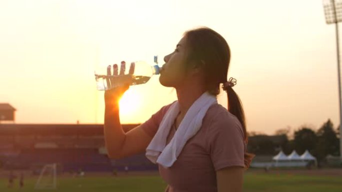 运动妇女饮用水饮水晨跑夕阳
